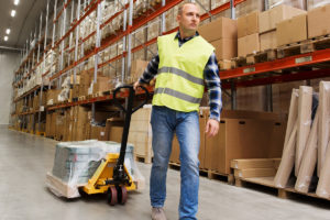 Man pulling cart in warehouse