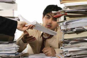 Overwhelmed man with mountain of work