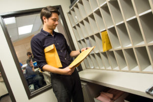 Man sorting mail in mailroom