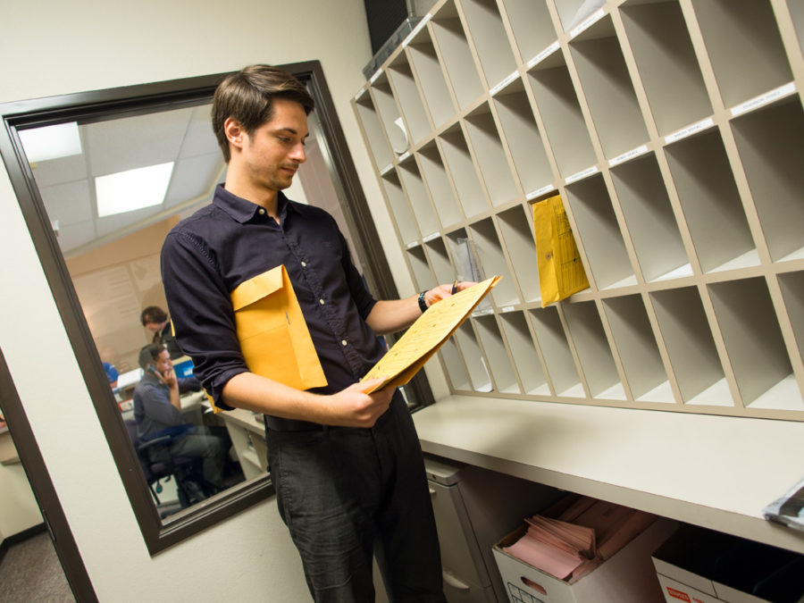 Man sorting mail in mailroom