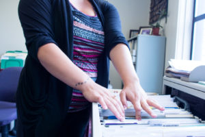 Female administrative employee filing for tax season staffing