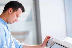 Male administrative assistant making copies